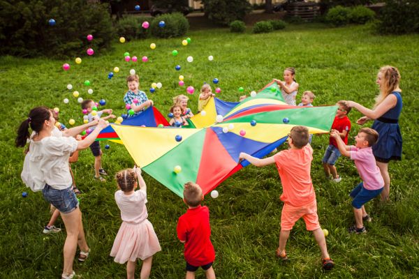 group of children playing with parachute and soft balls